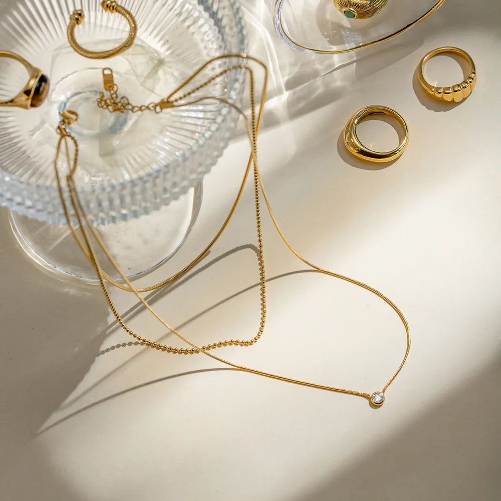 Colar camadas dourado em composicao minimalista